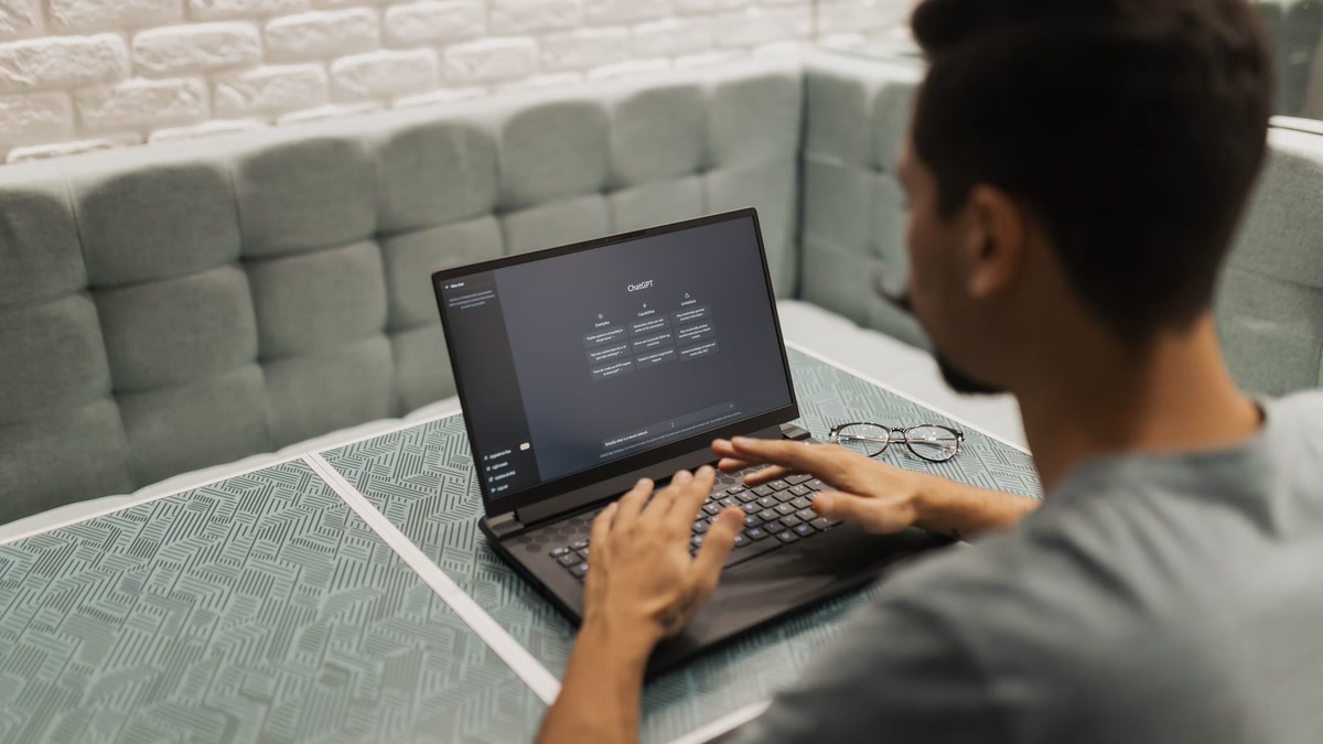 featured Person using a laptop with an AI chat interface on screen