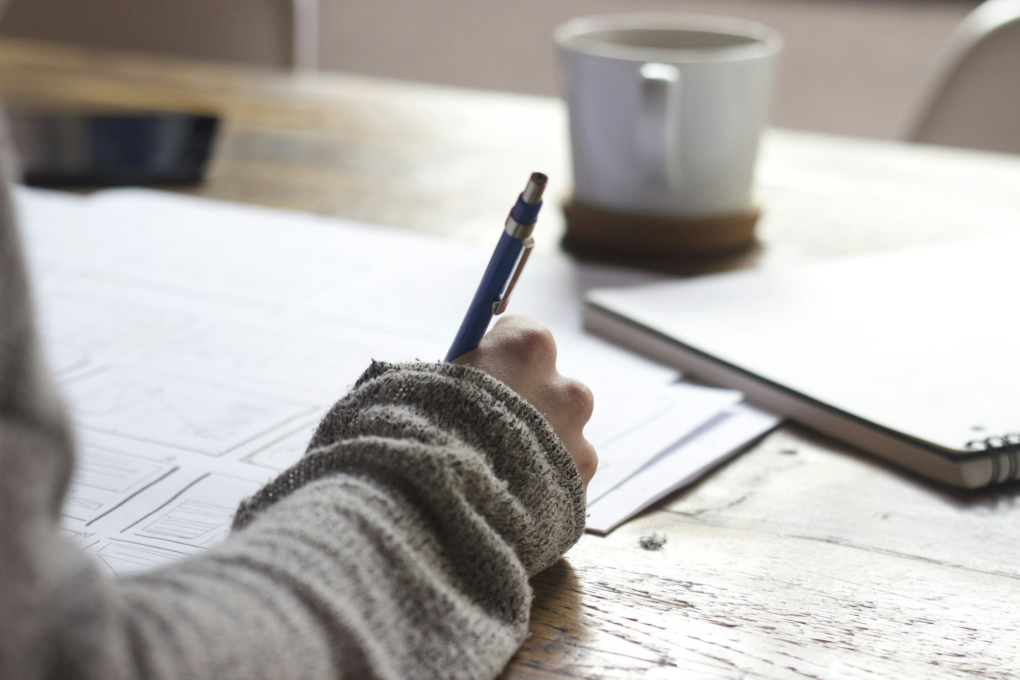 Freelancer sketching a client presentation deck at a desk