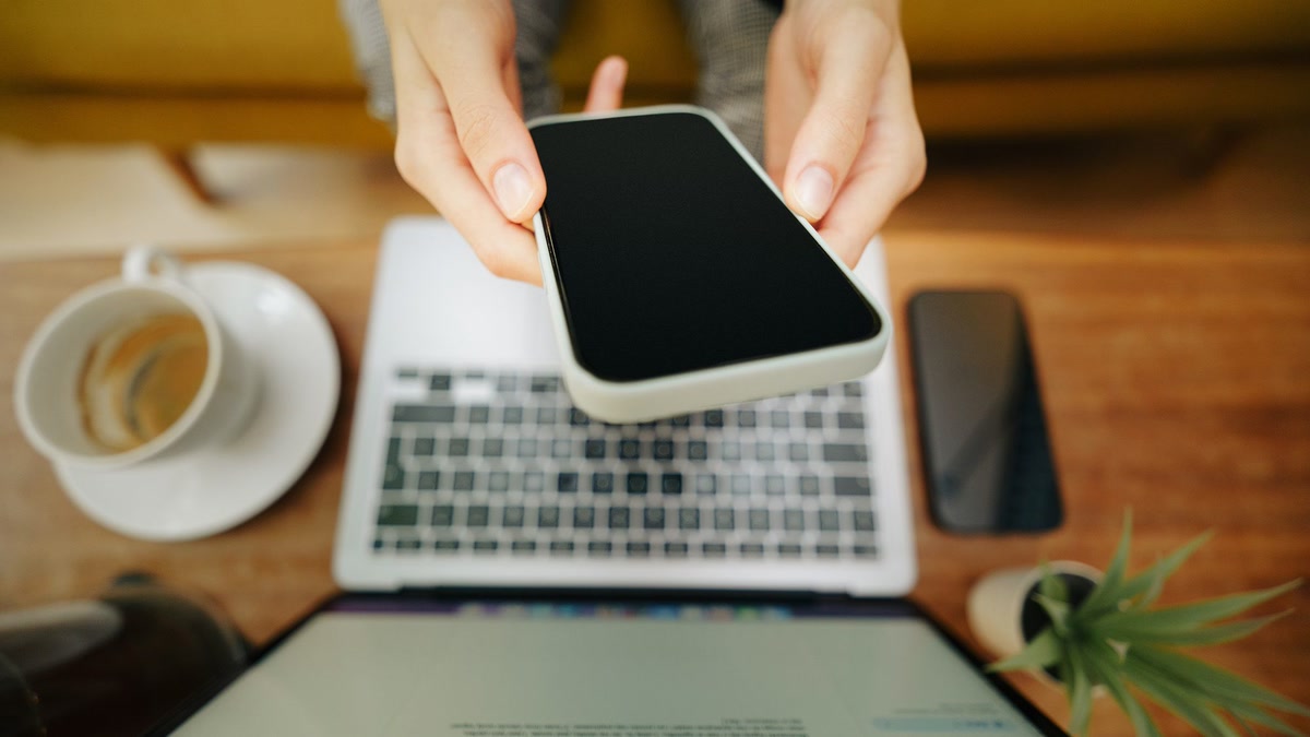 top-5-free-ai-tools-every-south-african-should-know-featured-16×9 Person using free AI tools on a phone and laptop