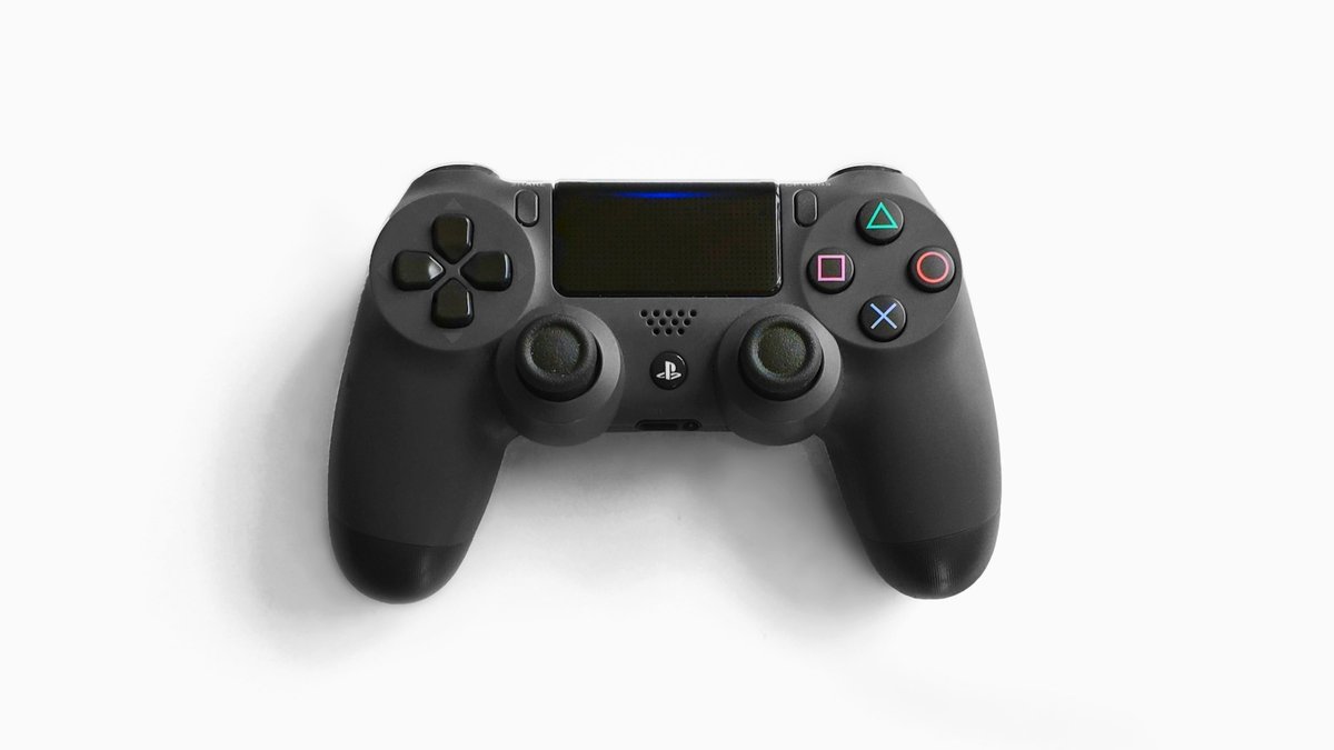 Black game controller on a white desk for a PS5 QSSR AI upscaling explainer
