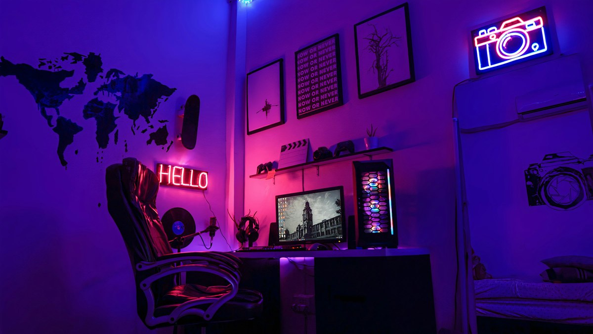 featured Neon-lit desk with a gaming PC and controllers for a guide to which PS5 games are coming to PC