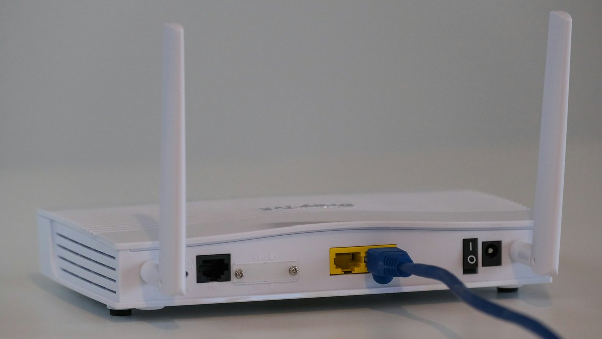 White home Wi-Fi router with antennas and an Ethernet cable, illustrating a Wi-Fi 8 buy-or-wait decision