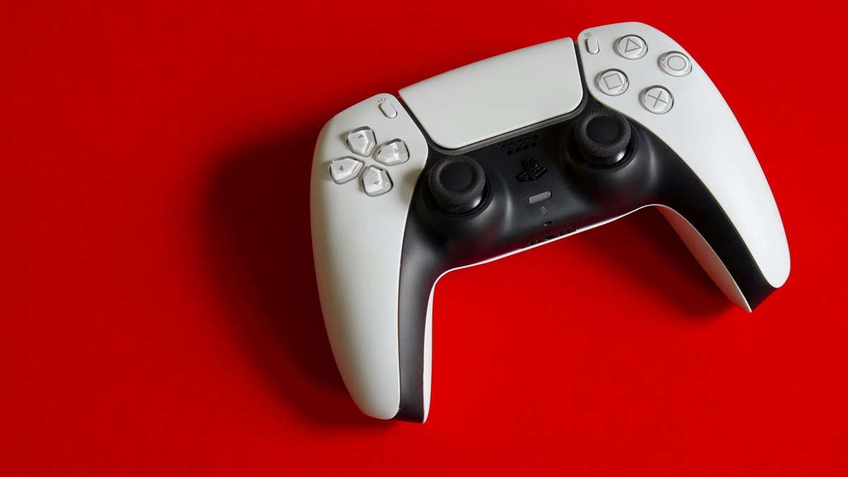 featured White game controller on a red surface for a PS5 Pro jailbreak explainer