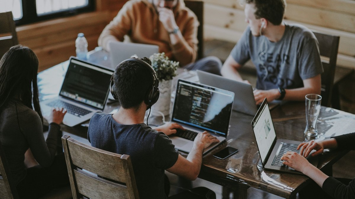 Freelance team working together on laptops around a shared table