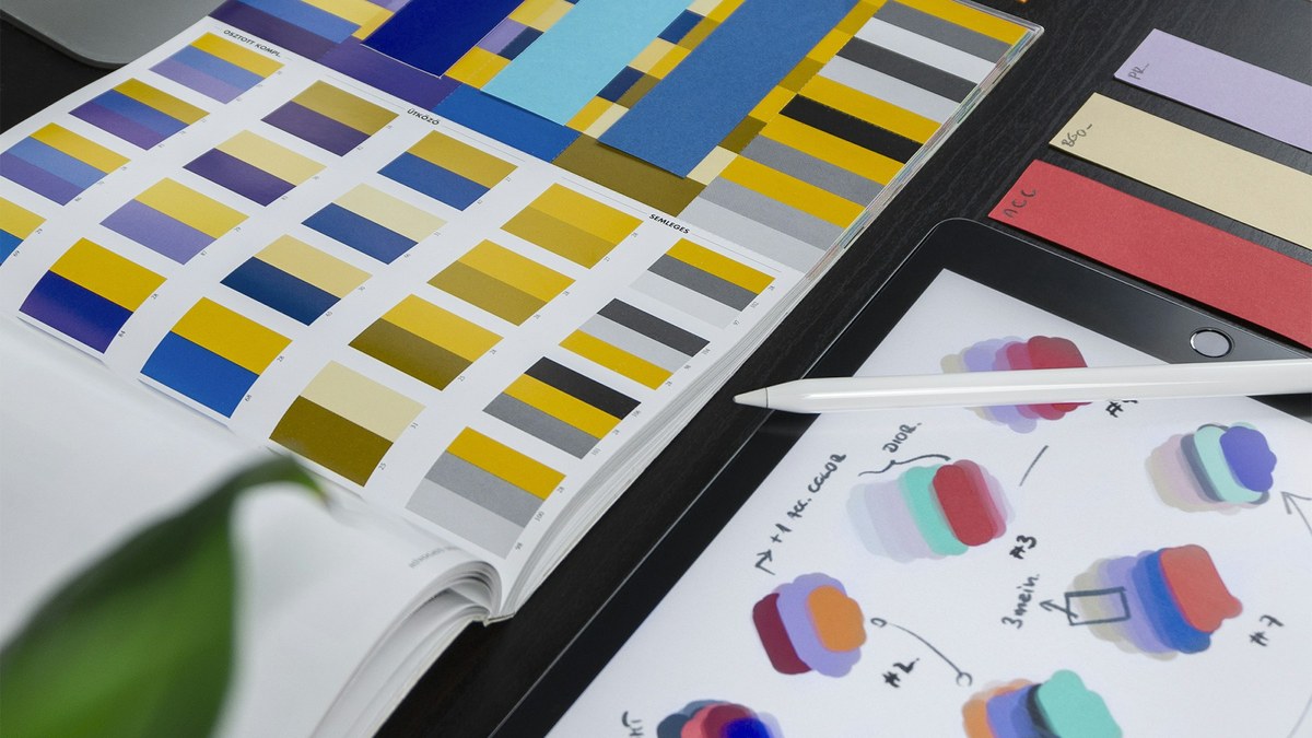 featured Design tools and color swatches on a desk for an Adobe Firefly AI Assistant try-or-skip decision